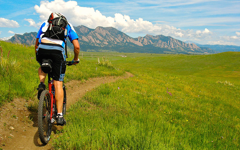 Photo of a man riding a mountain bike in the Flatirons – area with rock formations near Boulder, Colorado