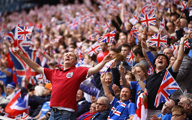 Photo of supporters waving Union Jack flags at a match