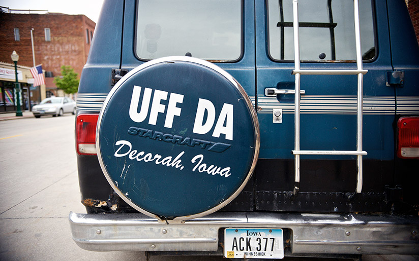 Photo of a car with a spare tire cover saying “UFF DA” in Norwegian, in Iowa